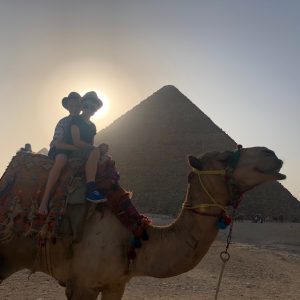 Two children on a camel at the pyramids